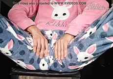 Young girl in pajamas plays with black vibrator, reaching orgasm on webcam