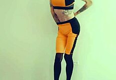 Feminized transsexual pornstar kneels in stockings and lingerie, eagerly sucking cock during interview.