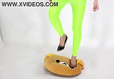 Beautiful legged woman steps on cushion with high heels, showcasing her shoe fetish.