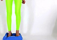 Beautiful legged woman steps on cushion with high heels, showcasing her shoe fetish.