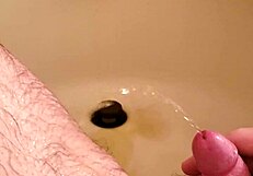 Old man unleashes golden shower on shaved small cock