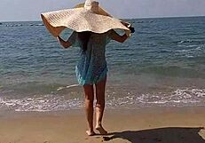 Huge-titted woman flashes her hairy pussy and small tits on a public beach.