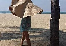 Huge-titted woman flashes her hairy pussy and small tits on a public beach.