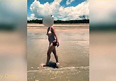 Wife strips nude for football on public clothed beach.
