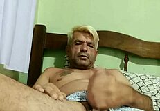 Two gay men engage in passionate anal sex with kissing and oral play in a private bedroom setting.