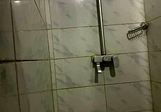 muscular gay bodybuilder showers barefoot in close up