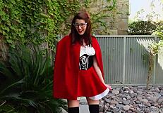 Amber Hahn in little red costume plays solo outdoors