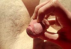 edging flaccid cock with precum in natural light