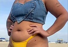 African woman flashes and arouses guy on beach.