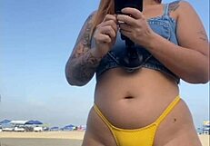 African woman flashes and arouses guy on beach.