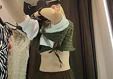 Blonde tries on clothes in mall fitting room