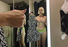 Blonde tries on clothes in mall fitting room