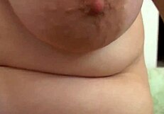 Titty slut fingers her tight pussy using a dildo while watching porn.