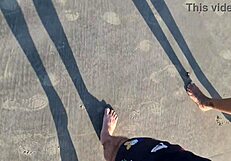 On the beach, she fingers her wet pussy under the sun.