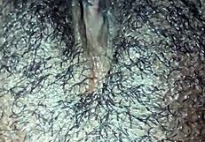 This ebony girl is playing with her hairy pussy