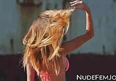 Stunning babe teases with shaved pussy and natural tits in slow motion at beach close up.