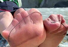 goddess teases with tan nylon soles and toes by the riverside, close-up fetish delight