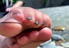 goddess teases with tan nylon soles and toes by the riverside, close-up fetish delight