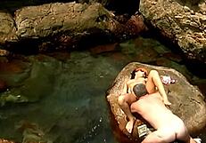 Mature Man Fucks Exotic Babe in Cap and Sunglasses on Seaside Stones.
