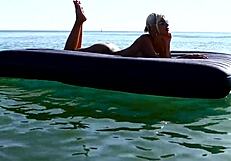 nude blonde beauty exposes big boobs on public beach with dolphin tattoo