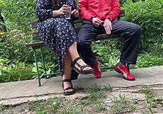 Milf subtly jerks big dick into glass on park bench
