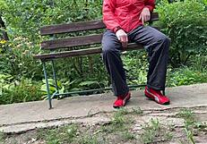 Milf subtly jerks big dick into glass on park bench