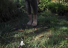 Barefoot toes tease and crush flowers across the grassy ranch