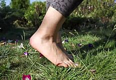Barefoot toes tease and crush flowers across the grassy ranch