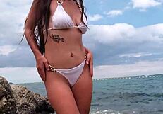 petite babe in tropical bikini teases on beach craving your gaze all over her sexy curves