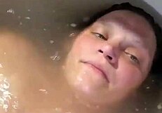 Woman enjoys extended bath session with self-touching and relaxation